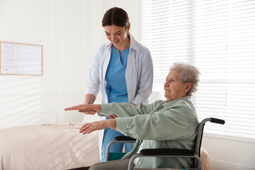 Senior woman in wheelchair doing physical exercise indoors. Home health care service