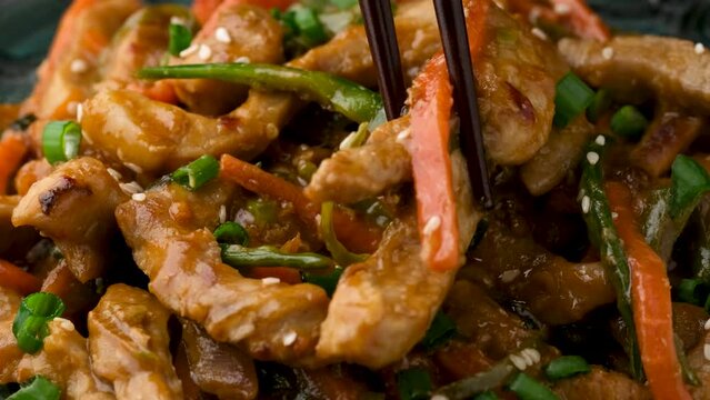 Eating Chinese sichuan shredded pork with vegetables. Asian cuisine
