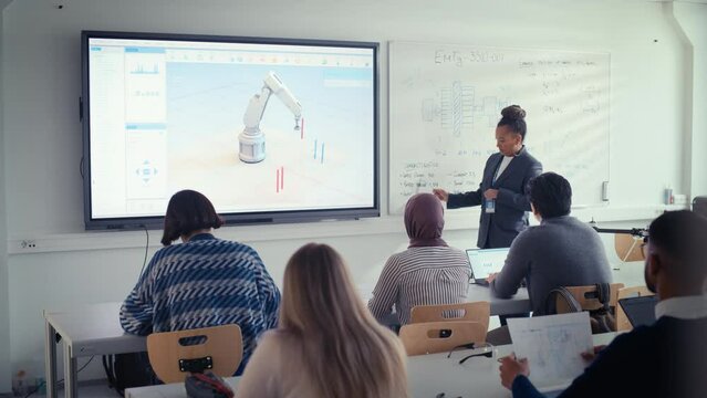 University Robotics Lecture Class: Black Teacher Explain Engineering to Students. She Uses Whiteboard. Diverse Group of Young Engineers Listen Lecture on Program Development for Robotic Arm Use