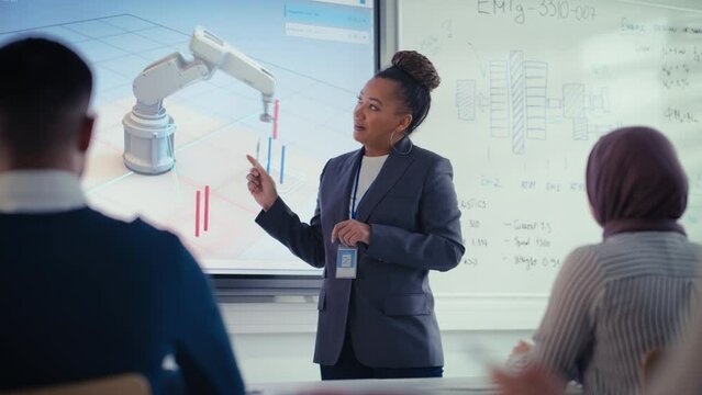 Black Lecturer Point at 3D of Robotic Arm Moves Objects and Discuss it with Students at Contemporary Auditorium. Formation of Modern Highly Intellectual Educational Environment Concept