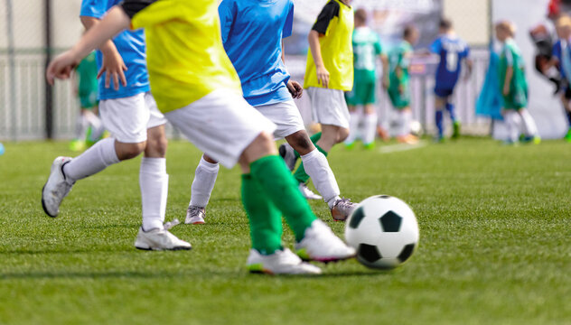 Football Boys Kicking Ball in Opposite Teams. Young Soccer Players Running in Duel and Playing Soccer Tournament Match. Sports Competition for Youth Athletes. School Training Pitch in Background