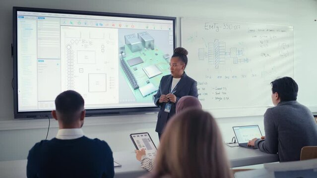Diverse Team of Computer Design Students Listen Black Teacher at Seminar, Watching Interactive TV that shows 3D Concept Model of Processor. Innovative Techniques in Instruction Technology Concept