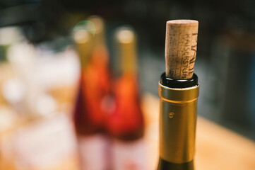 Ein Korken auf einer Weinflasche mit mehreren Flaschen Wein im Hintergrund 