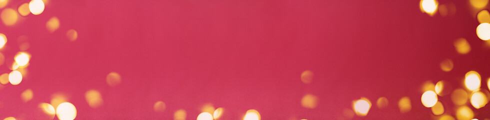 Banner of Christmas bright gold colors bokeh different sizes around the frame on vibrant pink blurred background. Holiday template and shiny greeting concept with copy space