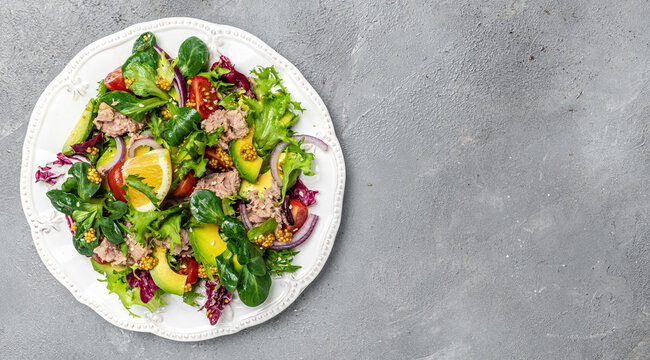 Tuna salad with lettuce, cherry tomatoes, avocado and red onions. Delicious breakfast or snack, Clean eating, dieting, vegan food concept. top view