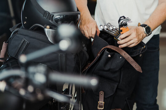 rider prepare the tools and put them in saddlebag or side bag before on a trip. motorcycle travel concept. selective focus