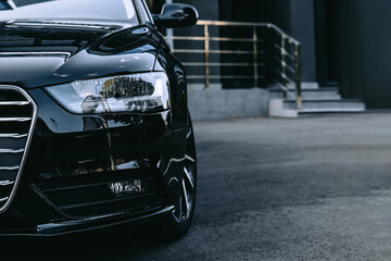 Modern car headlight close up. In front of the car at street. Copy space background. Automotive