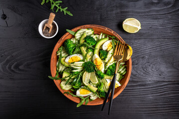 Ketogenic, paleo diet lunch bowl with avocado, cucumber, broccoli and egg. Healthy organic vegan salad. Delicious breakfast or snack, Clean eating, dieting, vegan food concept. top view - obrazy, fototapety, plakaty