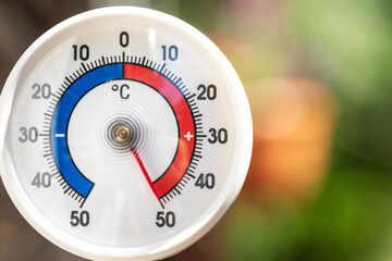 Outdoor thermometer shows extreme hot summer temperature