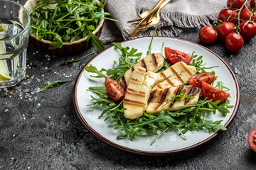 Fresh salad with grilled halloumi cheese, tomatoes, capers, lettuce and arugula. ketogenic paleo diet. Delicious breakfast or snack, Clean eating, dieting, vegan food concept. top view