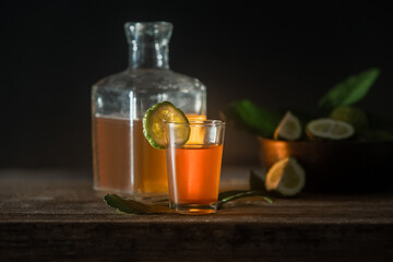 rum in a glass shot and bottle on dark wooden background, wealthy luxury bar atmosphere