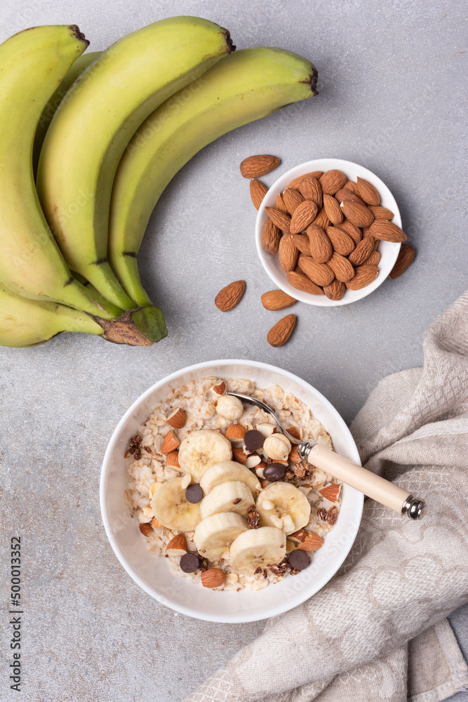 Wall mural healthy breakfast with oatmeal, nuts, banana and chocolate drops