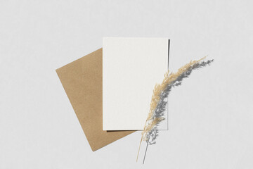 Blank greeting card, invitation mockup. Dry grass, pampas plant on white table background. Flat...