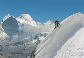 Rolgordijnen Mountain climber climbing steep snowed slope in spectacular mountain landscape   © IBEX.Media