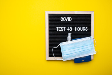 Coronavirus travel concept. Passport medical mask on a yellow background. Text covid 48 hours.