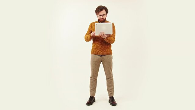 full shot of a young bearded man standing and working in laptop studio shot isolated copy space job concept. High quality 4k footage