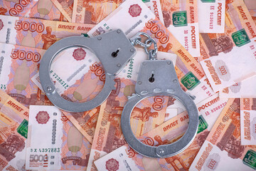 Handcuffs lying on the money. Background of Russian money.