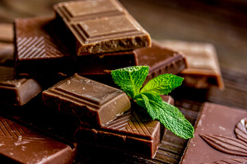 chopped chocolate pieces with mint for dessert wooden desk background