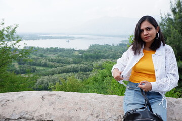 Beautiful girl sitting and enjoying the view of lansdscape dal lake from pari mahal top.