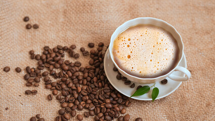cup of coffee and coffee beans in a sack on Brown background