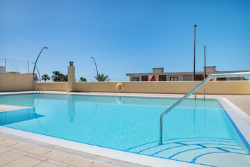 Spacious clean swimming pool built as part of a large residential complex designed for tourists and holidaymakers at Av. la Havana, Los Cristianos, Tenerife, Canary Islands, Spain