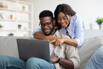 Portrait of African American couple using computer in living room