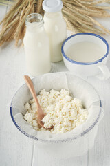 Shavuot jewish holiday celebration. Milk and cheese, ripe wheat and fruits, cream on white wooden background. Dairy products over white wooden background. Shavuot concept. Top view. Mock up.