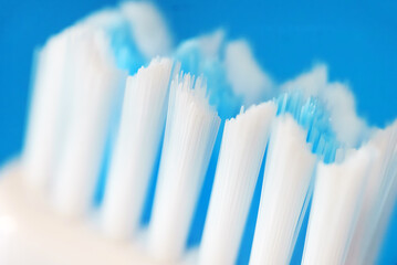 Electric ultrasonic toothbrush bristles on blue background.