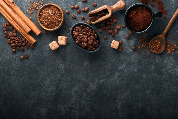 Coffee beans background. Roasted Coffee concept with differents types of coffee, beans and cinnamon sticks on dark black stone background. Top view. Coffee concept. Mock up.