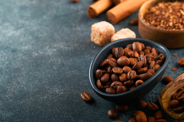Coffee beans background. Roasted Coffee concept with differents types of coffee, beans and cinnamon sticks on dark black stone background. Top view. Coffee concept. Mock up.