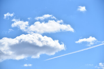 Jasna smuga na błękitnym niebie między jasnymi chmurami  - obrazy, fototapety, plakaty