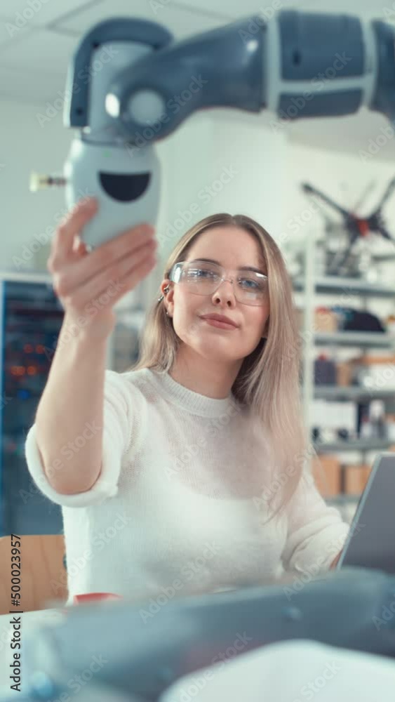 Poster Automation Female Engineer Type at Laptop and Move Bionic Claw At the Factory. Modern Equipment and New Era in Computer Science Industry Concept. Vertical Video