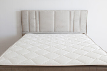 White orthopedic mattress top side surface pattern on unmade bed in the bedroom. Hypoallergenic...