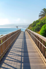Fototapeta na wymiar Straight narrow bridge with a view of the blue sea water against the sky in San Clemente, California