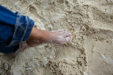 The feet and legs of tourists wearing jeans. standing on a beautiful sandy beach
