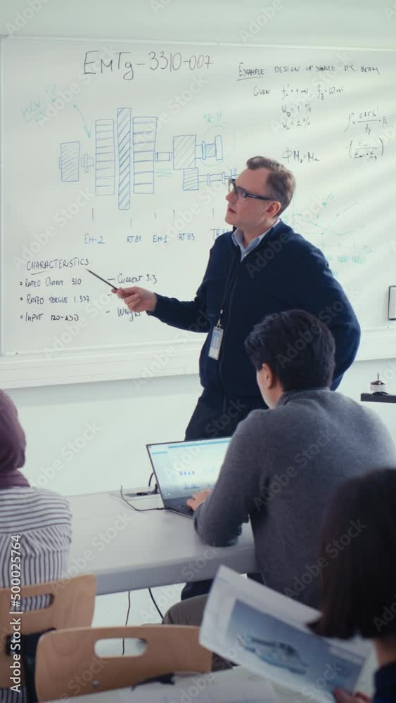 Aufkleber Male Teacher Explain Engineering to Students at University Lecture Class. He Uses Whiteboard. Diverse Group of Young Engineers Listen Lecture on Program Development. Education Concept. Vertical View