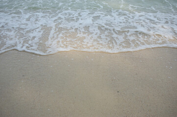 Sea waves crashing on the beautiful sandy beach.