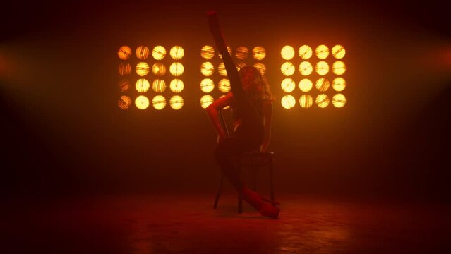 Woman showing sexy body performing striptease on stage. Hot blonde dancing.