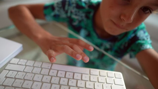 Child using computer keyboard typing space key