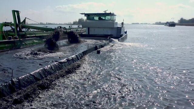 Dredging ship dredges off mud from river bottom to improve the fairway, river IJssel in the Netherlands, Aerial  