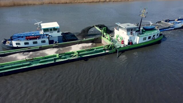 Dredging ship dredges off mud from river bottom to improve the fairway, river IJssel in the Netherlands, Aerial  