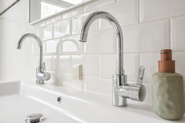 Ceramic sink with silver taps in contemporary bathroom