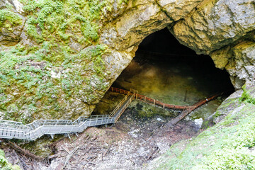 Entrance in The Scărişoara cave or Scărişoara Glacier shelters the largest underground glacier in Romania.