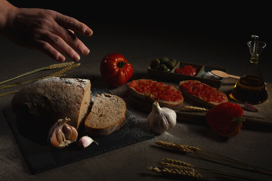 Unrecognizable person preparing bread with tomatoes