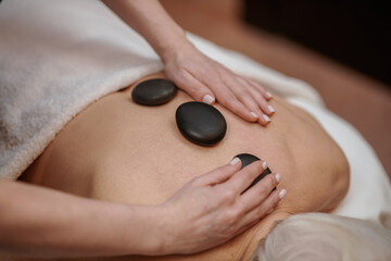 Close up picture of a woman having stone back massage