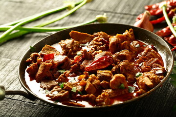 Homemade Indian beef curry roast cooked in iron skillet on wood fire. Traditional cokking concepts.