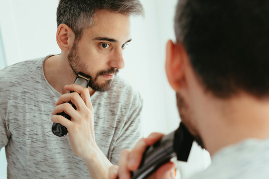 Man shaving beard with trimmer