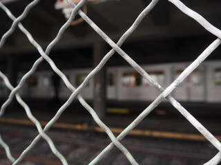 Fence with bokeh of subway passing by