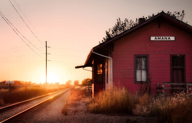 Wooden train depot with the text Amana by the railroad
