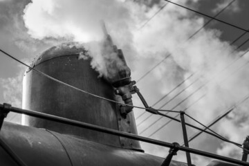 Closeup grayscale shot of a train steam engine with a whistle